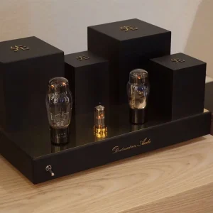 Three Vista 3-Way Horn Speakers of varying sizes displayed on a black staircase-like stand with the logo "Destination Audio" inscribed, set against a wooden surface.