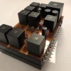A Phono Stage amplifier on a base, featuring multiple black electronic components. A Phono Stage amplifier on a base, featuring multiple black electronic components.