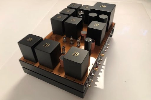 A Phono Stage amplifier on a base, featuring multiple black electronic components. A Phono Stage amplifier on a base, featuring multiple black electronic components.