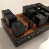 A Phono Stage amplifier on a base, featuring multiple black electronic components. A Phono Stage amplifier on a base, featuring multiple black electronic components.