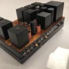 A Phono Stage amplifier on a base, featuring multiple black electronic components. A Phono Stage amplifier on a base, featuring multiple black electronic components.