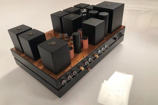 A Phono Stage amplifier on a base, featuring multiple black electronic components. A Phono Stage amplifier on a base, featuring multiple black electronic components.