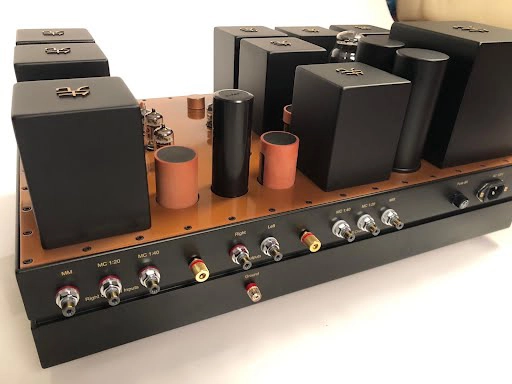Audio mixing console with multiple input jacks and a series of black and copper controls on a Destination Audio desk, featuring The Phono Stage. Audio mixing console with multiple input jacks and a series of black and copper controls on a Destination Audio desk, featuring The Phono Stage.
