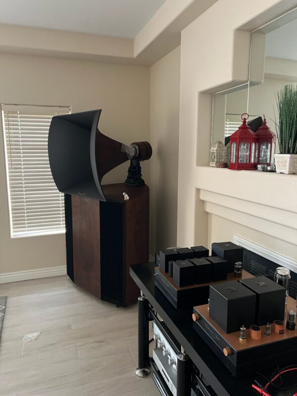 Vista 3-Way Horn Speakers sit by the fireplace, flanked by two red lanterns on the mantle, while audio equipment rests on a black table in front. Vista 3-Way Horn Speakers sit by the fireplace, flanked by two red lanterns on the mantle, while audio equipment rests on a black table in front.