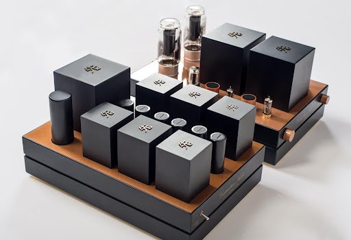 An elegant tea set arranged on a tray, featuring black geometric containers with metallic accents and glass cups styled like GM70 Integrated Amplifiers. An elegant tea set arranged on a tray, featuring black geometric containers with metallic accents and glass cups styled like GM70 Integrated Amplifiers.