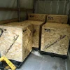 Three large wooden crates labeled "Vista 3-Way Horn Speakers" inside a shipping truck, arranged with a pallet jack nearby. Three large wooden crates labeled "Vista 3-Way Horn Speakers" inside a shipping truck, arranged with a pallet jack nearby.
