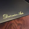 Close-up of the gold text "Vista 3-Way Horn Speakers" on a black amplifier with a wooden panel visible below. Close-up of the gold text "Vista 3-Way Horn Speakers" on a black amplifier with a wooden panel visible below.