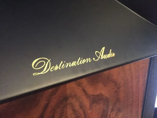 Close-up of the gold text "Vista 3-Way Horn Speakers" on a black amplifier with a wooden panel visible below. Close-up of the gold text "Vista 3-Way Horn Speakers" on a black amplifier with a wooden panel visible below.