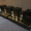 A Vista 3-Way Horn Speakers preamplifier with visible vacuum tubes and sleek black casing, displayed on a gray fabric surface. A Vista 3-Way Horn Speakers preamplifier with visible vacuum tubes and sleek black casing, displayed on a gray fabric surface.