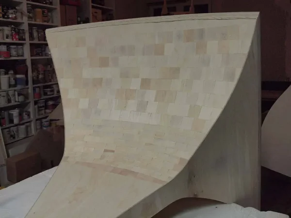 A Vista 3-Way Horn Speakers structure covered with small square tiles, located in a workshop with shelves filled with audiophile supplies in the background. A Vista 3-Way Horn Speakers structure covered with small square tiles, located in a workshop with shelves filled with audiophile supplies in the background.